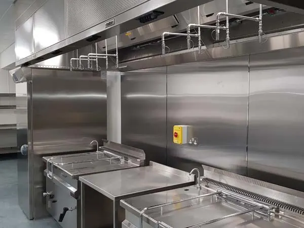 A restaurant kitchen suppression system with nozzles over the cook line